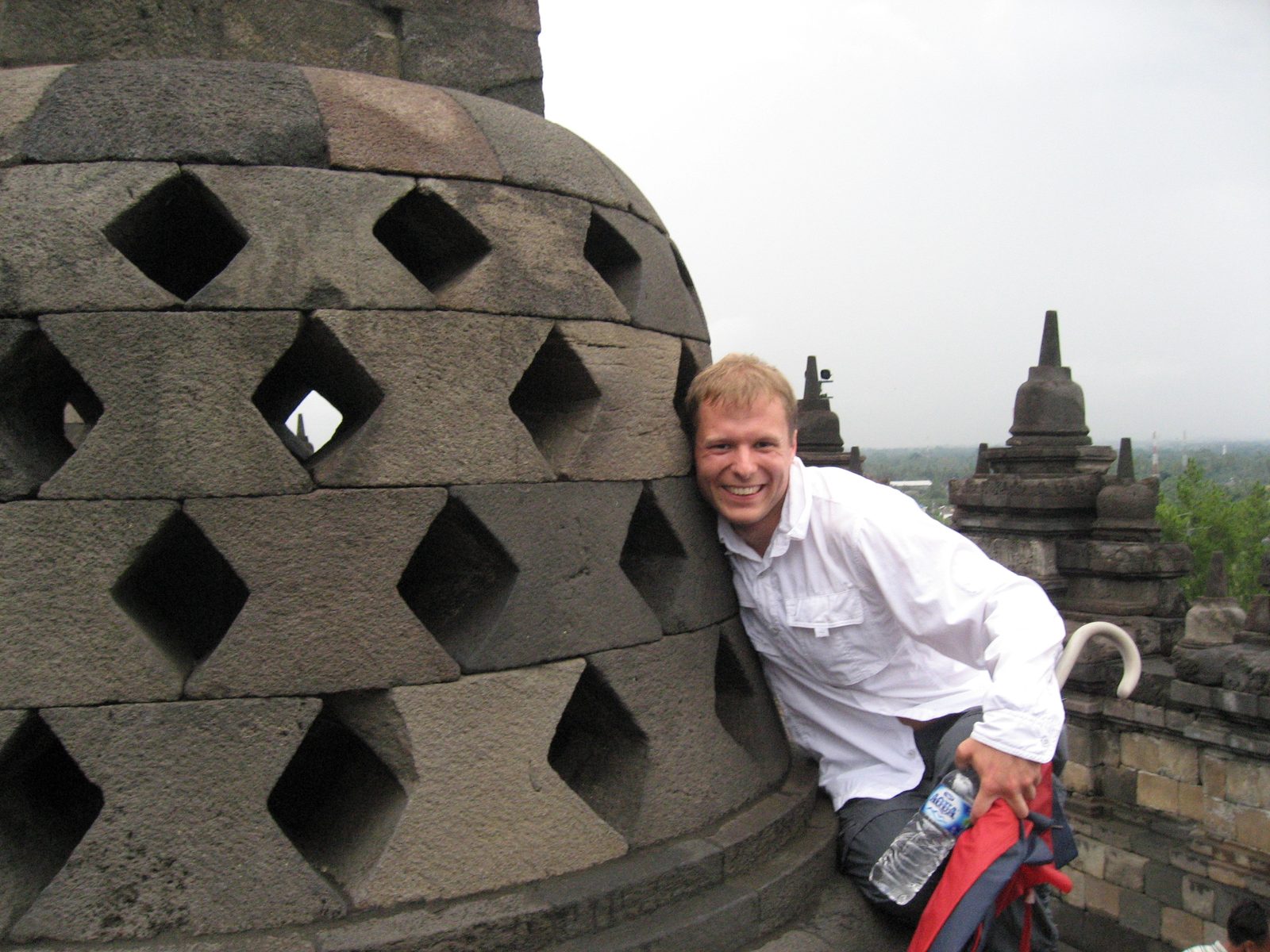 John trying to touch the finger of the lucky Buddha.
