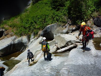 Tommer, Jon, and John downclimb in the water course. ...