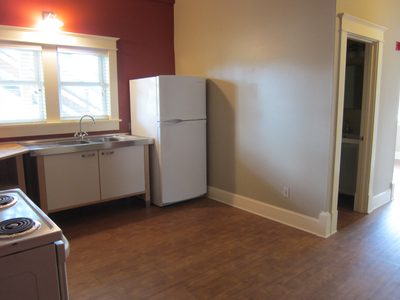 More kitchen, with bathroom doorway visible.