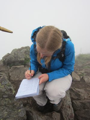 Diana writes her name in the summit register (kept in...