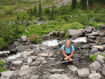 Catherine by a stream through a beautiful meadow.