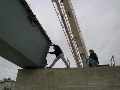 Tim pushes the girder into a more exact location; Dennis...