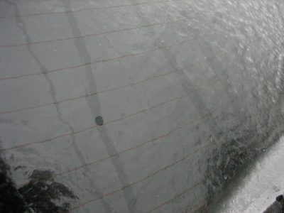 Water droplets run down back windshield on the inside of...