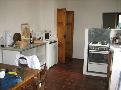 The kitchen, dining table, door to the living room (back...