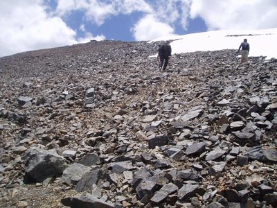 Srambling the scree field to avoid snow across the...