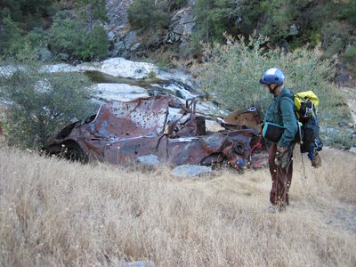 Joel inspects our favorite junked car at the river's...