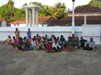 A school class sits and either prays or spaces out.