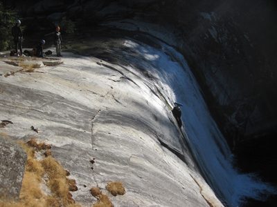 Joel on rappel, sliding on his hip to prevent slipping.