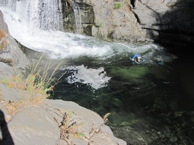 Joel swimming with a backpack.