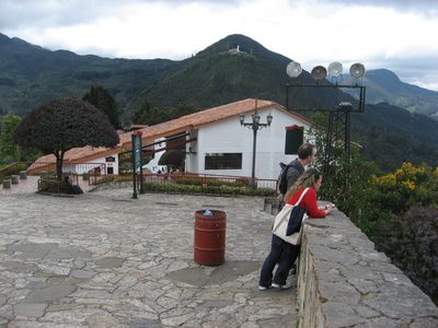 Some tourists gaze out at the city.  A large statue of...