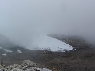 The toe of the glacier, mostly wrapped in fog.