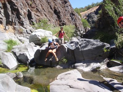 Christina slides over a boulder in upper Conda Coolero.