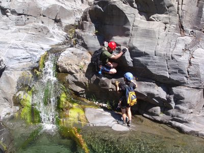 Monica gives Chris a hand getting down a small waterfall.