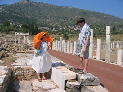 Nick and Clea's mom standing on the toilets of ancient Messene.