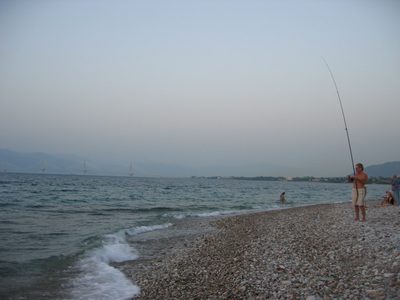 Some fisherman dude with the Rion-Antirion bridge in the...