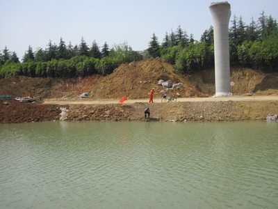 Elevated train track tower, old man fishing in the muck,...
