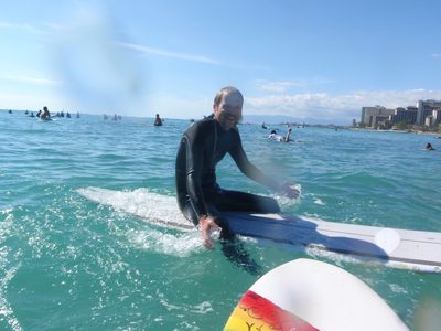 John, waiting for a wave with countless other surfers. ...
