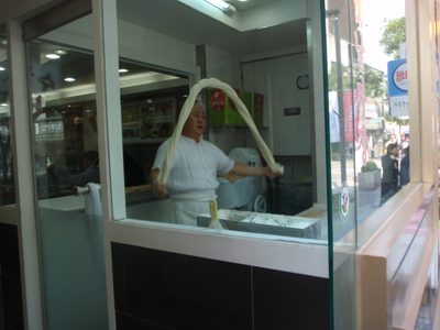 A chef making hand pulled noodles in a Chinese...