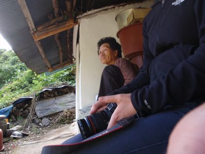 Old woman sitting outside the house where Monica´s dad...