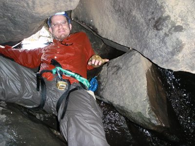 Joel squeezes through the passageway.