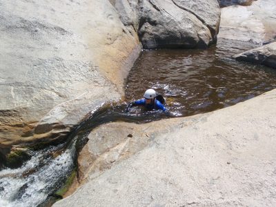 Catherine swims up to a small waterfall / slide.