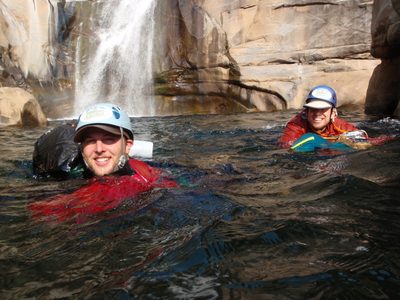 Mike and Joel paddling down river with bags (bottom of...