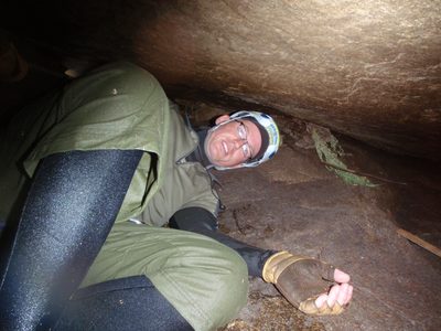 Andy, working his way under a boulder that smelled of guano.  