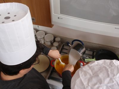 Jesse and Monica pouring 6 cups of sugar into 6 cups of...