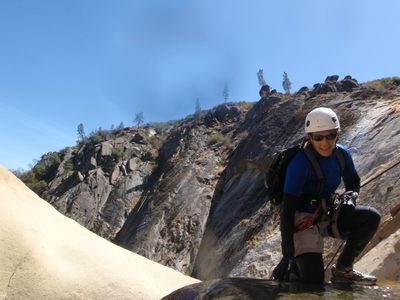 Catherine, on rappel, kneeling on the lip of the falls...