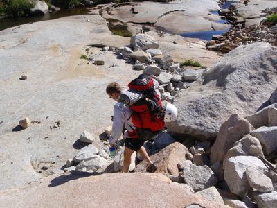 Climbing over some boulders near the top of the Pywiack Cascades.