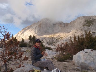 Dong, cooking dinner at camp as the clouds roll in over Conness.