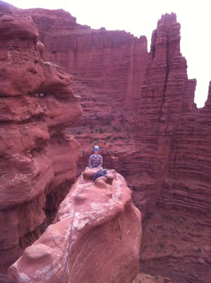 At the top of pitch 3: Monica sits at the belay looking...
