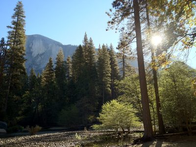 Sun rises above the shoulder of Half Dome during the...