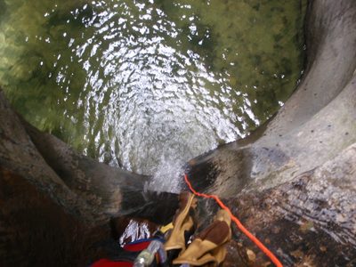 Looking down a rappel into a cold, deep pool.  It is...