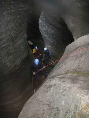 Mike rappels while Joel watches and Andy plays with his...