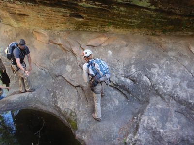 Andy holds out a hand to help Meredith cross a puddle of...