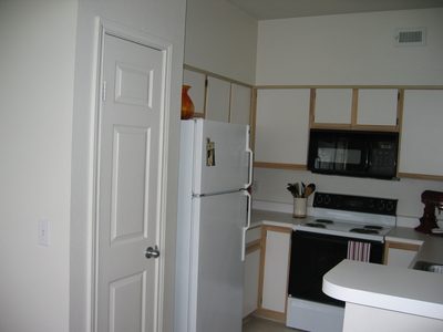 Kitchen showing full sized pantry next to the 'fride.