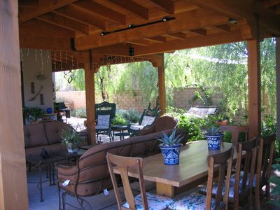 Covered outdoor living area with couches, chairs, and...
