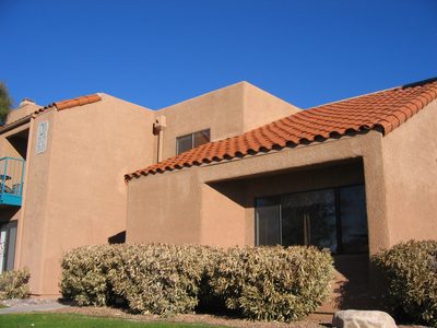 ... and the front entrance is around the left side of the bushes.