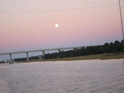 The full Carolina moon was rising as the sun was...