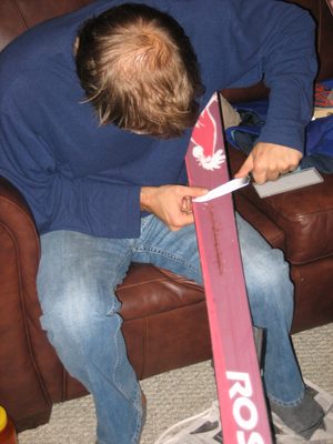 John scraping excess p-tex off a ski as part of a...