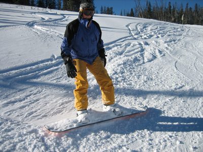 Catherine and her snowboard covered with snow.