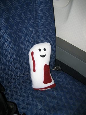 Bacon-y sits in his (quite spacious) coach seat on his...