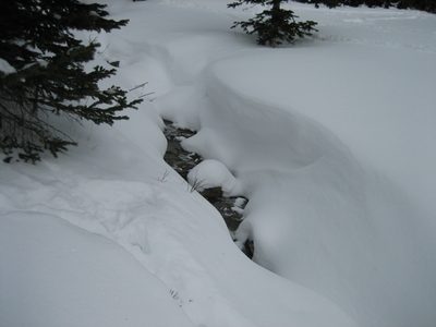 The Beehive Basin drainage peeking out between windblown...