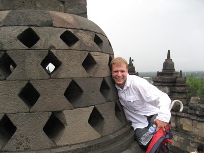 John trying to touch the finger of the lucky Buddha.