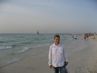 John on the beach in Dubai, near the Burj al Arab.